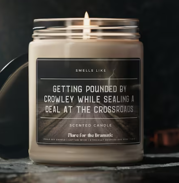 Candle whose label reads 'Getting pounded by Crowley while sealing a deal at the crossroads'